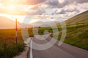 Country winding road in summer on sunset