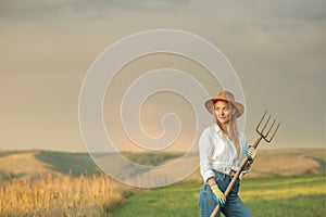 Country woman in field with pitchfork. Harvest festival