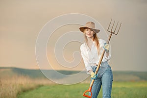 Country woman in field with pitchfork. Harvest festival