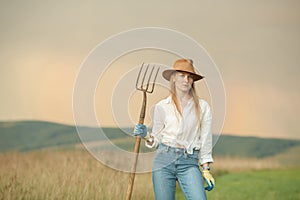 Country woman in field with pitchfork. Harvest festival