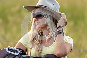 Country woman with saddle in farm setting