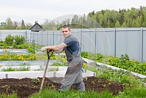 Country of work. At the dacha, a man cultivates the land for planting.