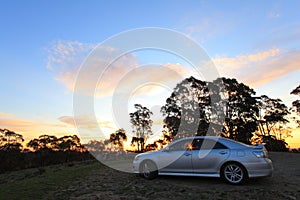 Car at scenic drive in rocky region by sunset photo