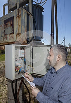 Countryside electric substation, farmer Inspecting electricity