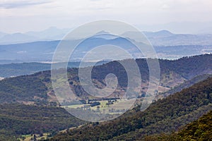 Countryside with forested hills and grassy plains.