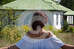 Countryside girl woman in summer Ukrainian village, back view. Summer vacation