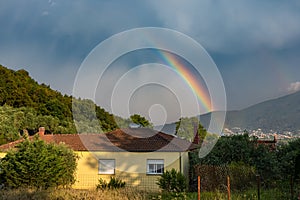 Countryside house over stormy sky with rainbow, traditional mountainous village, Thassos Island, Greece