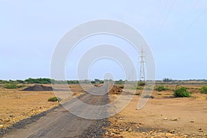 Countryside in India - Road Less Traveled - Soil, Small Road, Electricity Transmission Towers, and Sky - Village Transport
