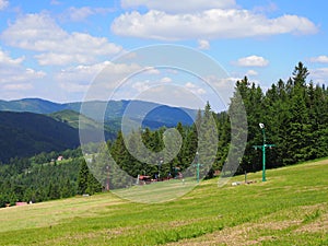 Countryside landscape of grassy field and forest at Beskid Mountains range on Bialy Krzyz in POLAND photo