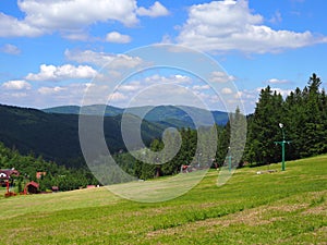 Countryside landscape of grassy field and forest at Beskid Mountains range on Bialy Krzyz in POLAND photo