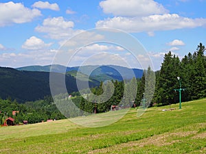 Countryside landscape of grassy field and forest at Beskid Mountains range on Bialy Krzyz in POLAND photo