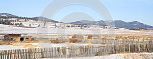 Countryside landscape with hay behind a fence against the backdrop of the Far Eastern hills.