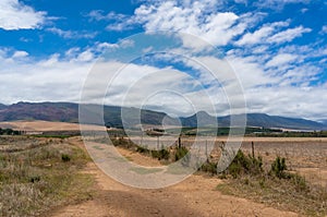 Countryside landscape with unsealed dirt road and mountains