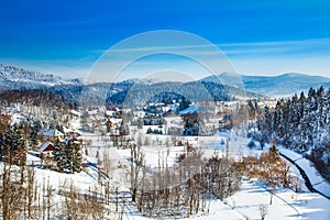 Countryside landscape in winter in Croatia, panoramic view of town of Lokve under snow in Gorski kotar