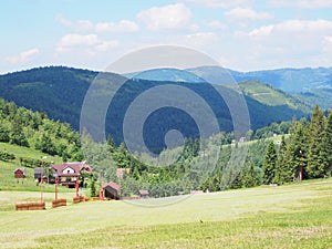 Countryside landscape of grassy field and forest at Beskid Mountains range on Bialy Krzyz in POLAND photo