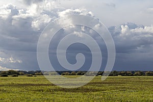 Countryside fall landscape with blue sky, puffy white clouds and autumn colors