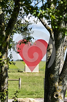 Countryside passion concept, big red heart in the middle of the fields