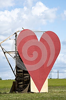 Countryside passion concept, big red heart in the middle of the fields