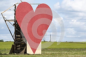 Countryside passion concept, big red heart in the middle of the fields