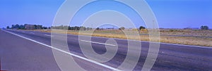 Countryside paved road on hilly landscape covered by meadows and trees, in a sunny day near buenos aires A small rural village