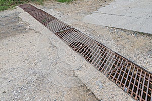 Countryside road drainage grate rusty metal steel grid grill mud