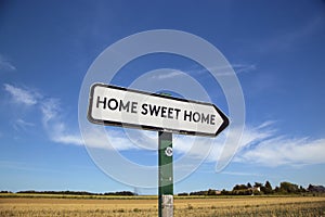 In the countryside a road sign with the inscription home sweet h