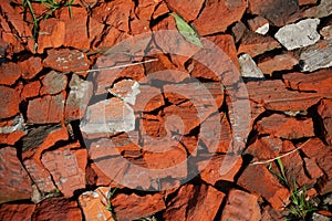 Countryside road surface made of broken red bricks.