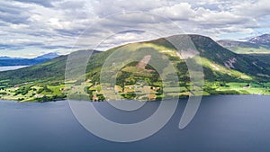 Countryside road to the sea in summer in Alnes, godoy island, Norway. Aerial shot from drone of norway landscape