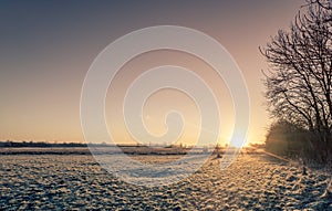 Countryside sunrise over a frozen field