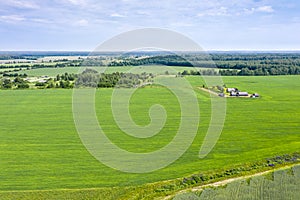 Countryside view from above with cultivated fields and farm under blue sky. aerial photo