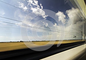 Countryside view in motion in the window of the fast moving train