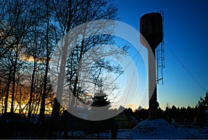 Countryside water tower during dramatic sunset background