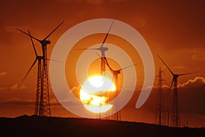 Countryside with wind turbines and the setting sun