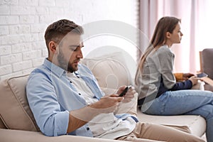 Couple addicted to smartphones ignoring each other. Relationship problems