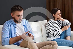 Couple addicted to smartphones ignoring each other. Relationship problems