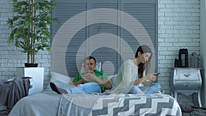 Couple addicted to smartphones phubbing at home