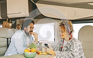 Couple of adult tourist enjoy leisure time together inside a modern camper van. Renting motor home for summer travel holiday