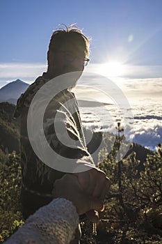 Couple of adventure travelers. SIlhouette of man follow woman holding hands hiking on mountain landscape. Couple enjoying hiking