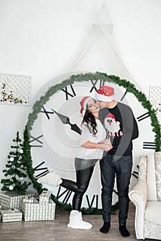 Couple against big clock showing new year`s midnight