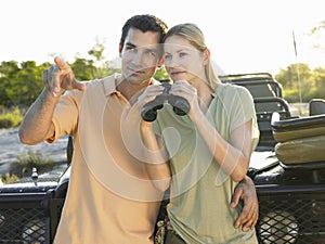 Couple Against Jeep With Binoculars
