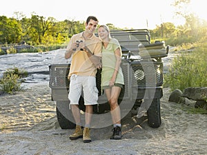 Couple Against Jeep With Binoculars