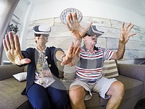 Senior couple playing at home with virtual reality goggles headset photo