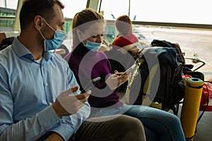 Couple at airport using smartphone travel app.