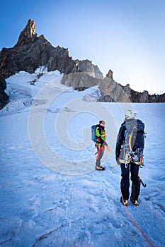 Couple alpinists mountaineers walking glacier  slopes. Mont Blanc