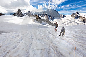 Couple alpinists mountaineers walking glacier  slopes. Mont Blanc photo