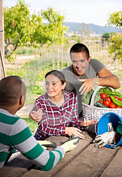 Couple of amateur gardeners discussing with neighbor outdoors