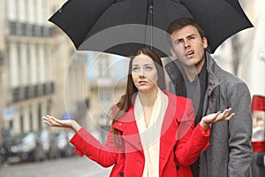 Couple annoyed in a rainy day