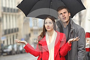 Couple annoyed in a rainy day photo
