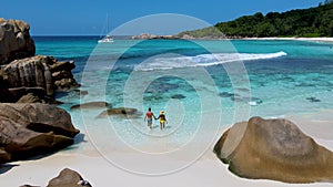 Couple on Anse Cocos beach turqouse colored ocean or Petite Anse Beach Seychelles La Digue Island