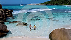 Couple on Anse Cocos beach turqouse colored ocean or Petite Anse Beach Seychelles La Digue Island
